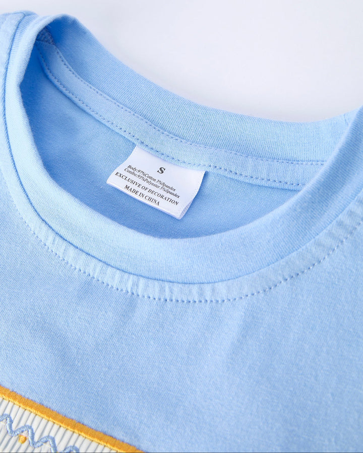 Close-up of a light blue shirt with a tag on a white background
