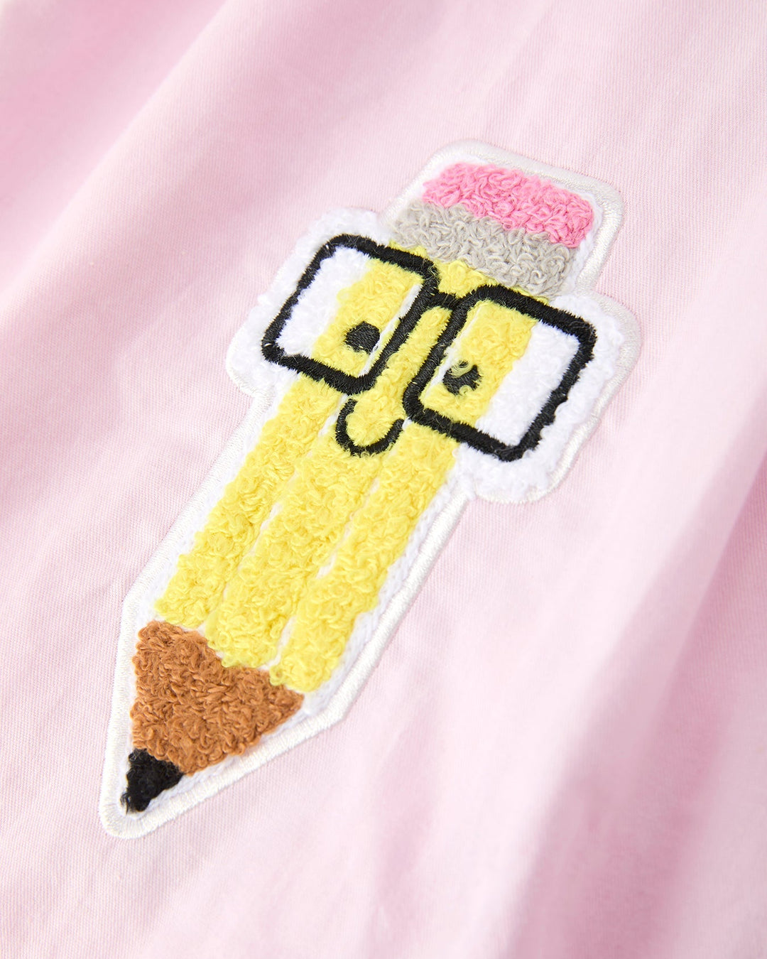 Embroidered patch of a yellow pencil with a pink eraser on a pink background