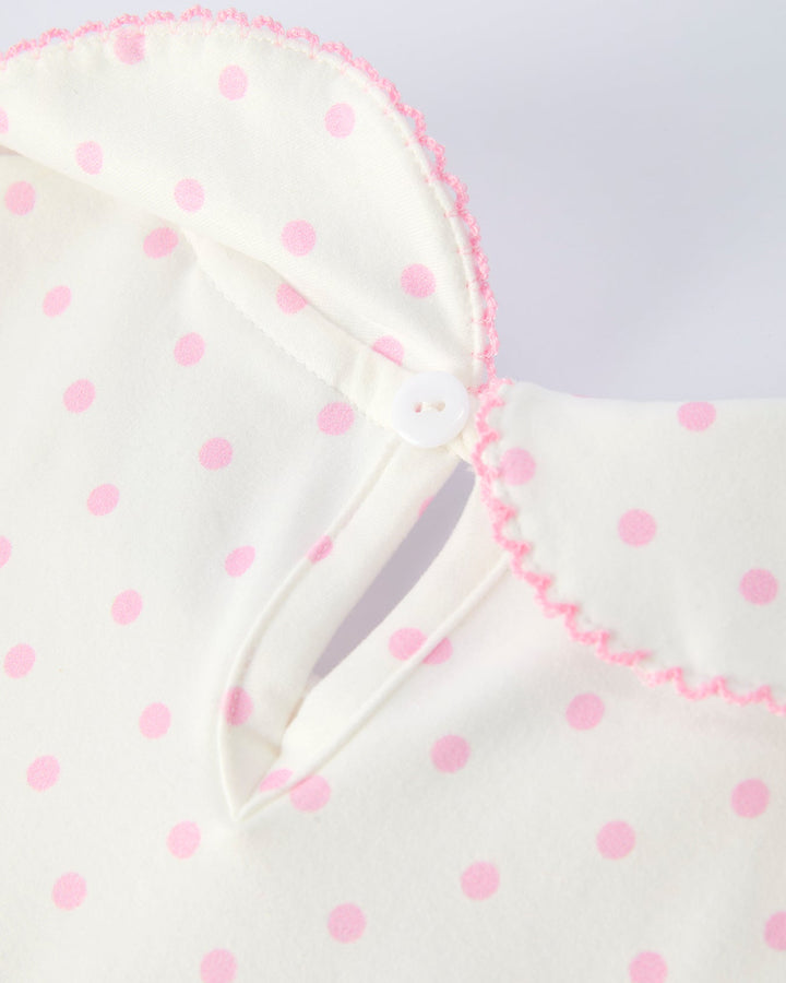 White garment with pink polka dots on a light gray background