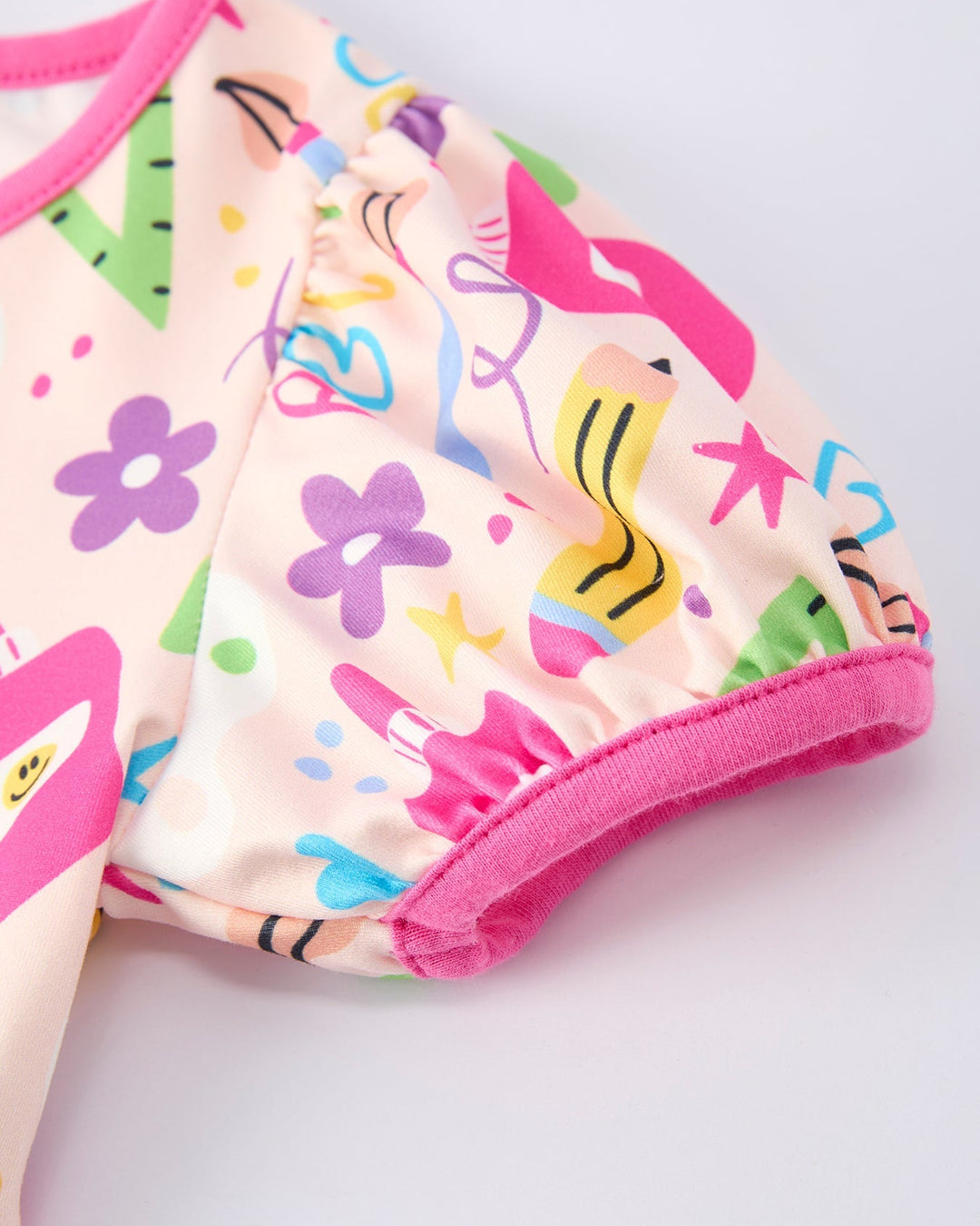 Colorful dress with pencil designs on a light pink background