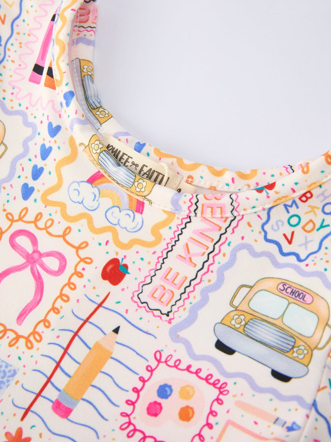Colorful stationery-themed fabric with school-related designs on a white background