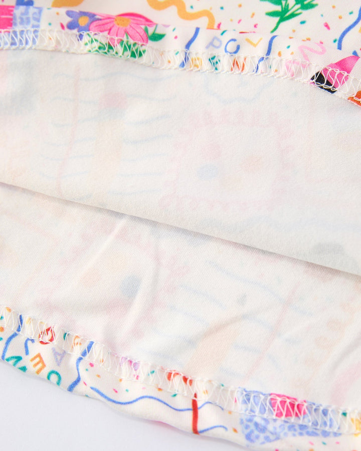 Close-up of a dress with colorful ruffled trim on a white background
