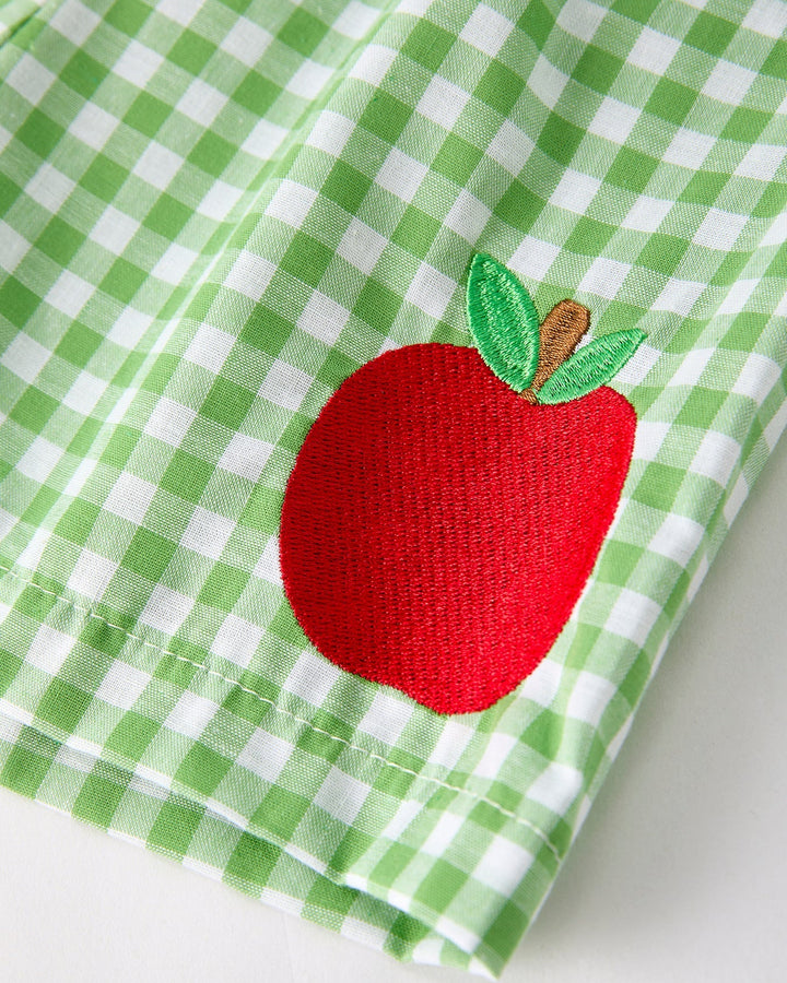 Green checkered shrts with a red apple design on a white background