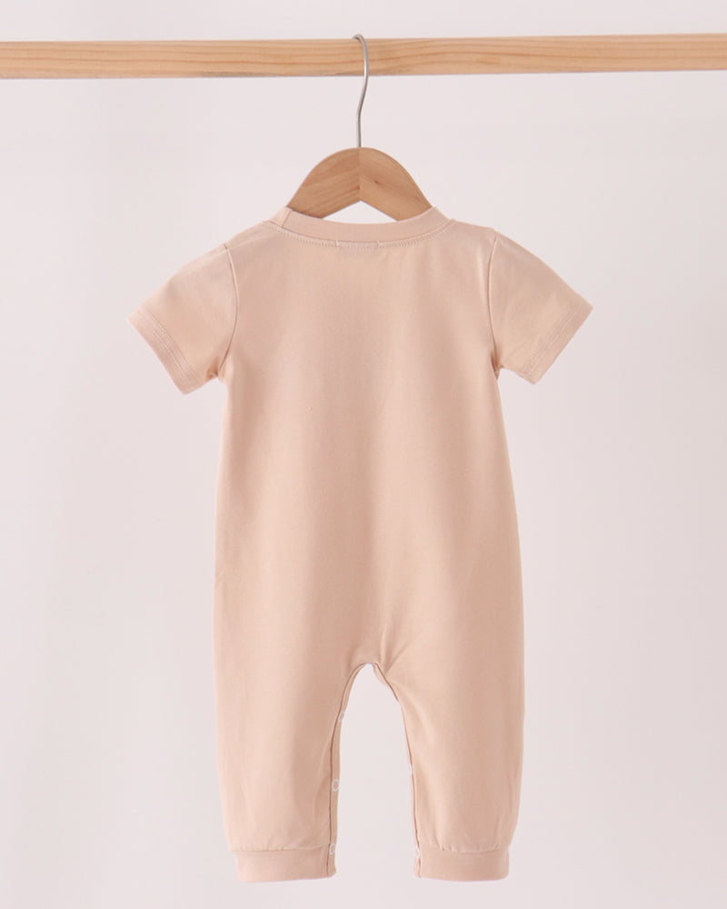 Beige short-sleeve footed romper, plain back with crew neckline and cuffs.