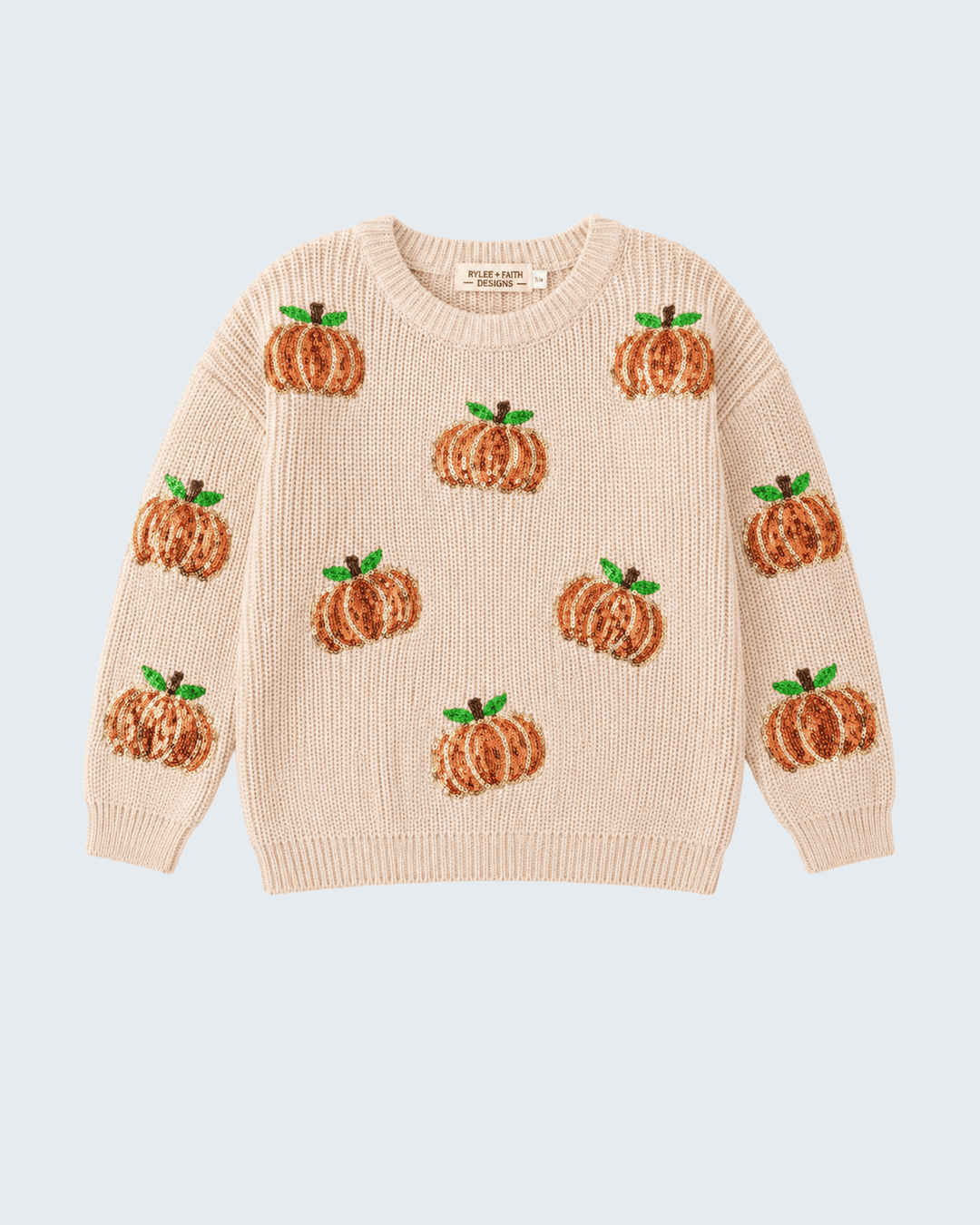 A cream-colored knit sweater featuring an all-over pattern of embroidered orange pumpkins with green leaves, displayed flat against a light blue-gray background.