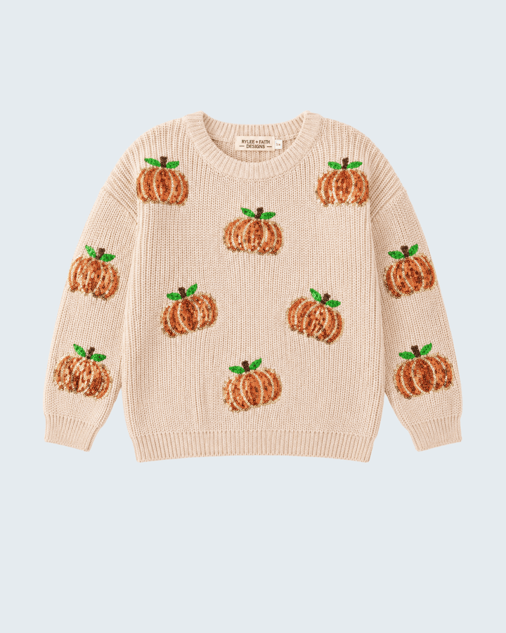 A cream-colored knit sweater featuring an all-over pattern of embroidered orange pumpkins with green leaves, displayed flat against a light blue-gray background.