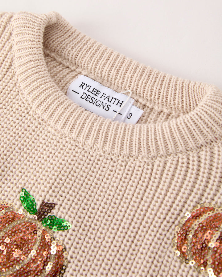 Beige knit sweater collar with brand label and sequin pumpkin accent