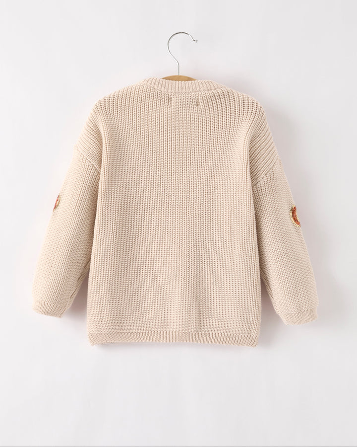 Beige knit sweater, crew neck and long sleeves, plain back with sequin pumpkin detail