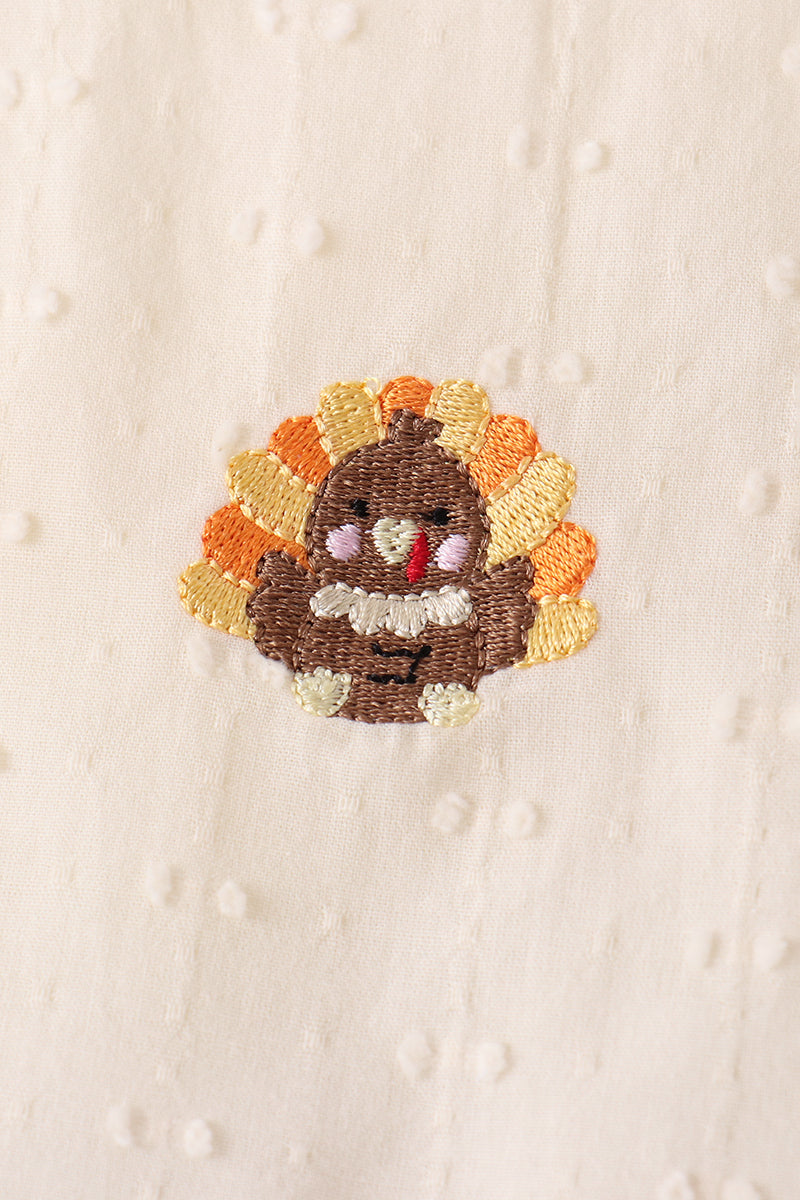 Embroidered autumn turkey motif patch on cream fabric