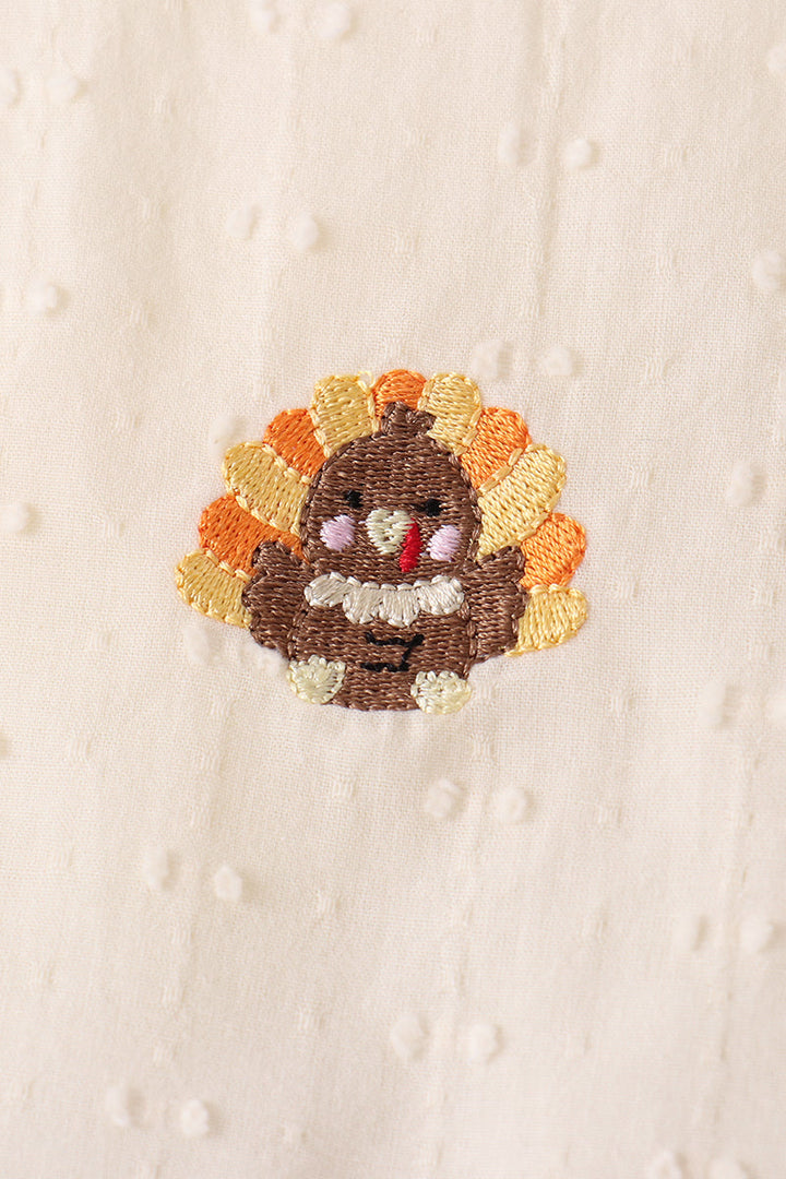 Embroidered autumn turkey motif patch on cream fabric