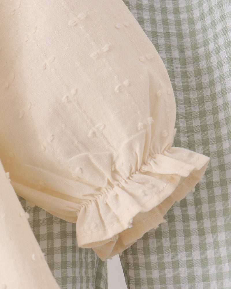 Cream dress sleeve with textured fabric and gathered cuff ruffle detail