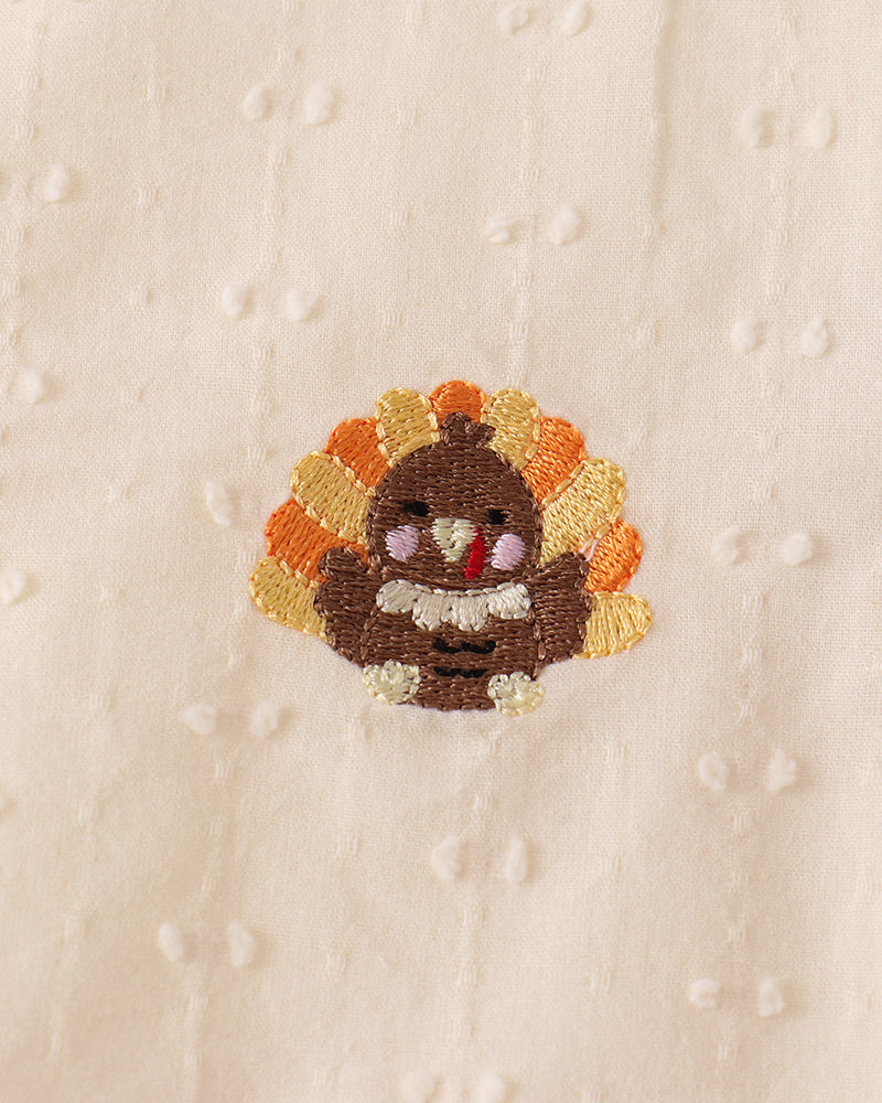 Cream fabric with embroidered flower patch detail