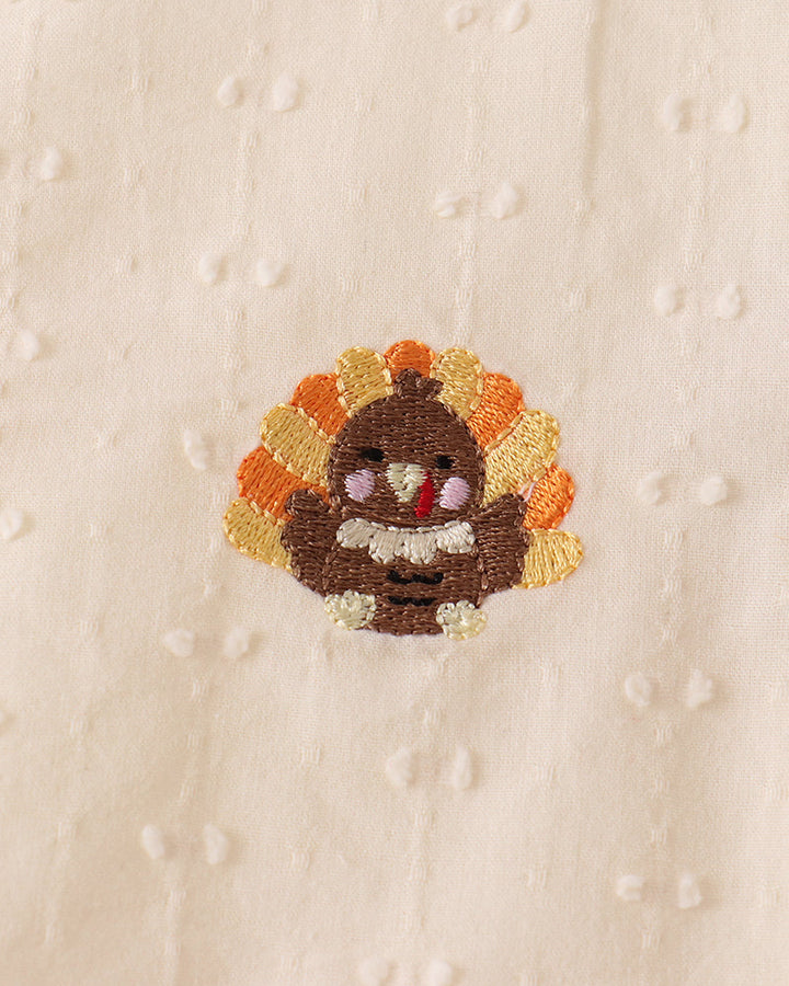 Cream fabric with embroidered flower patch detail
