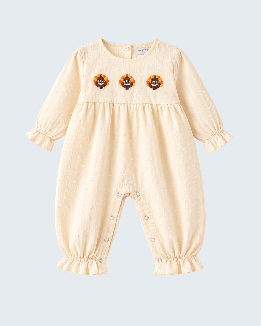 Beige embroidered ruffle romper with long puff sleeves and snap legs