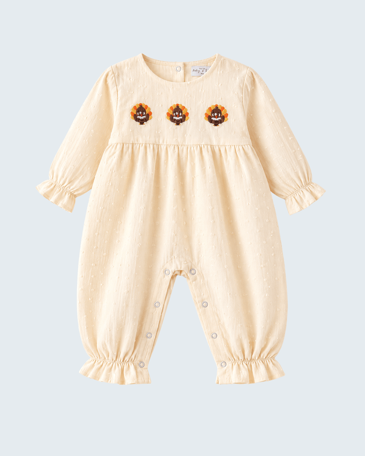 Beige embroidered ruffle romper with long puff sleeves and snap legs