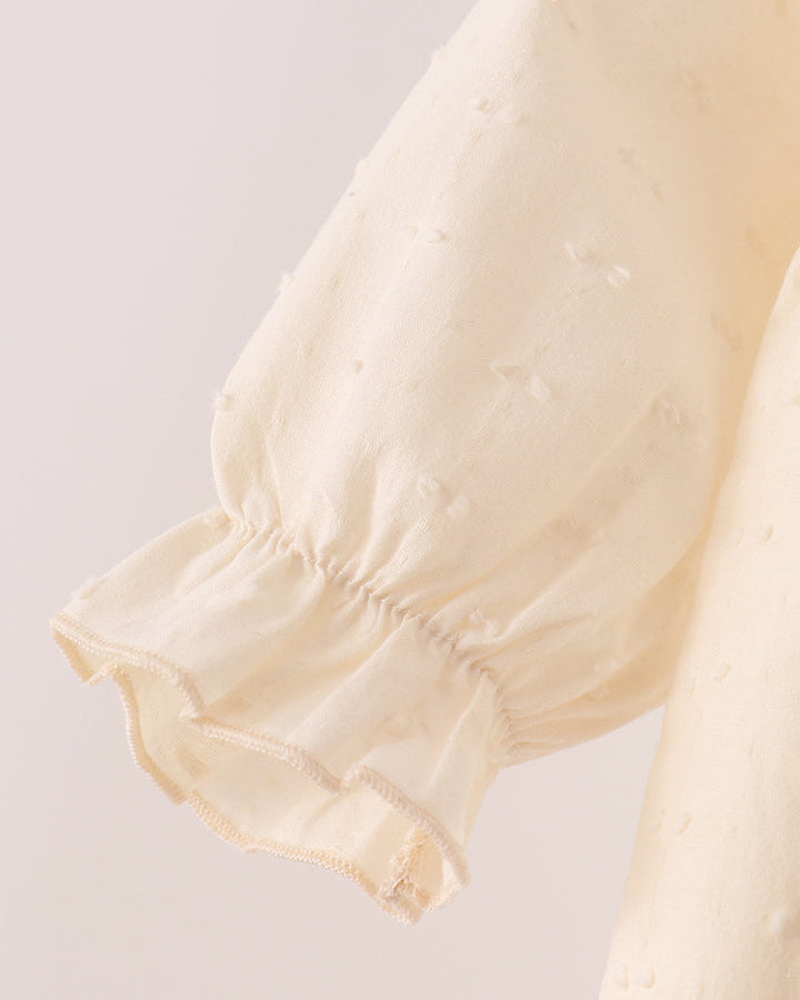 Cream romper sleeve with gathered cuff and delicate ruffled hem