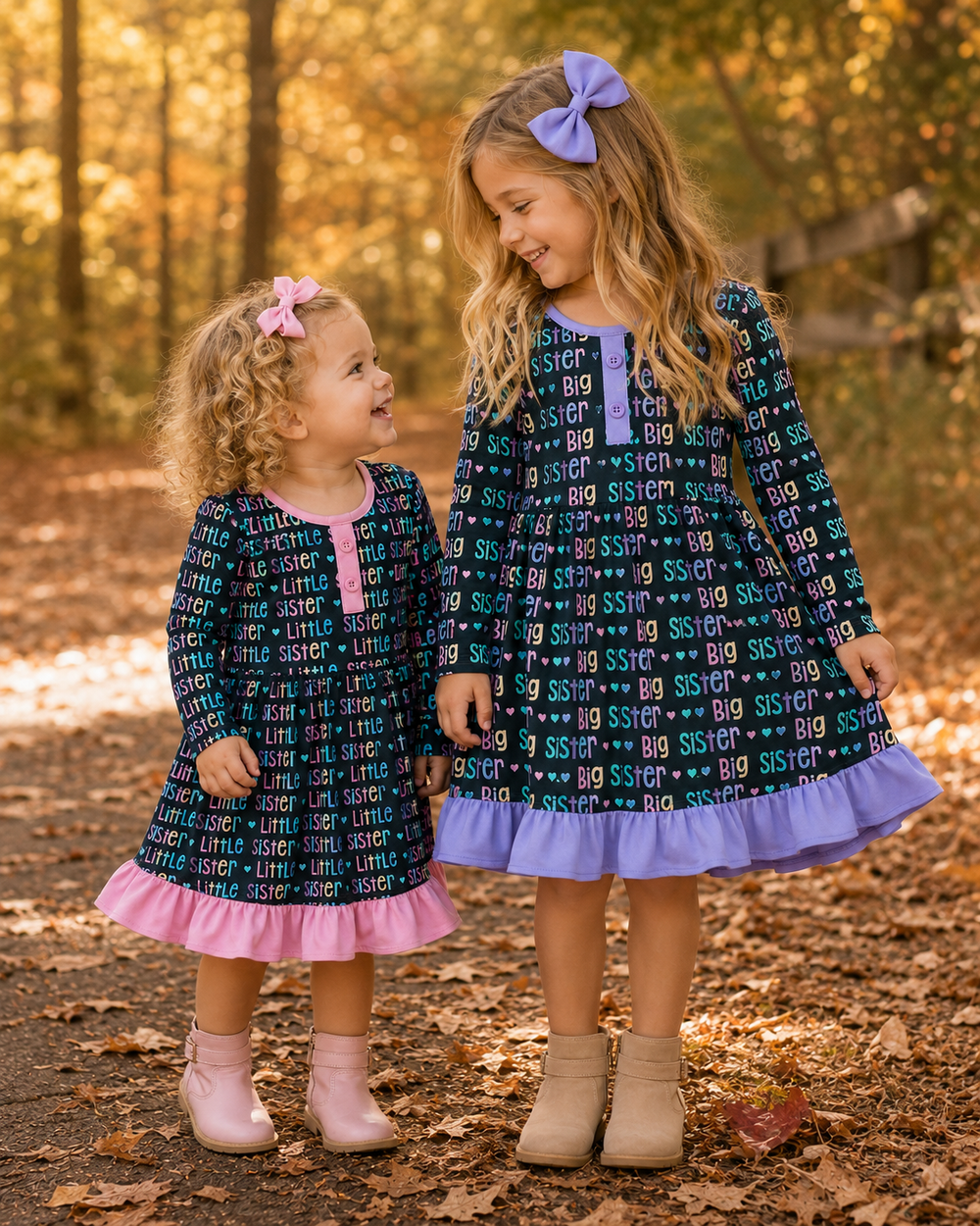 Two young girls in matching dresses standing in a forest during autumn.