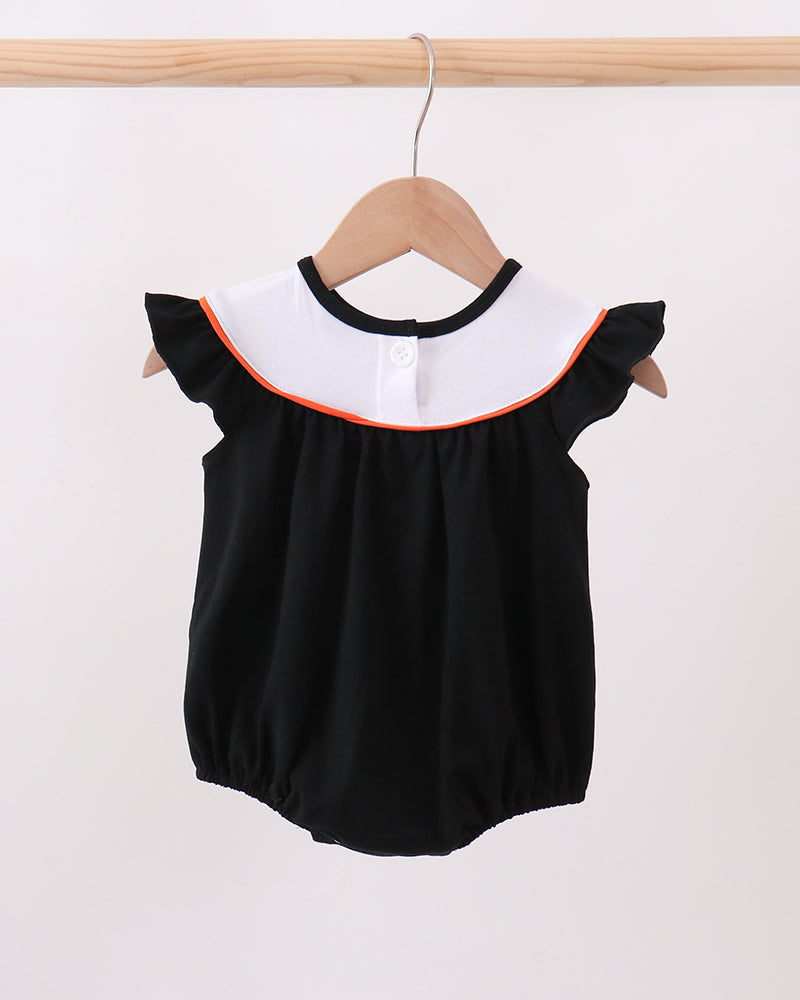 Black baby romper with white ruffle bib, orange trim, and embroidered cat and pumpkin motifs