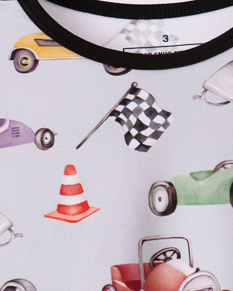 Racing pajama neckline close-up with black trim and car-themed print on light fabric