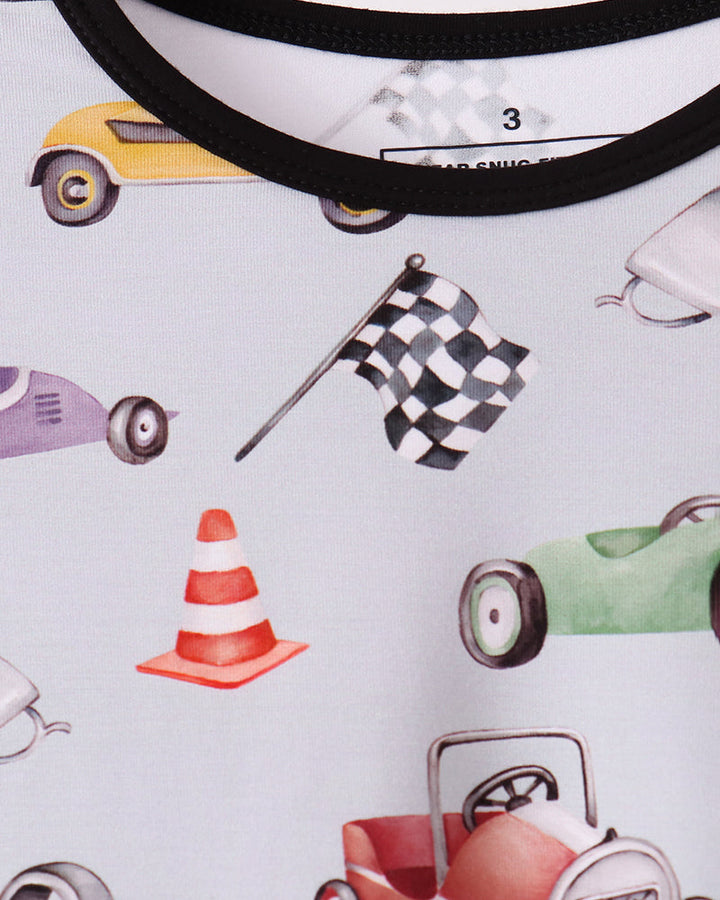 Racing pajama neckline close-up with black trim and car-themed print on light fabric