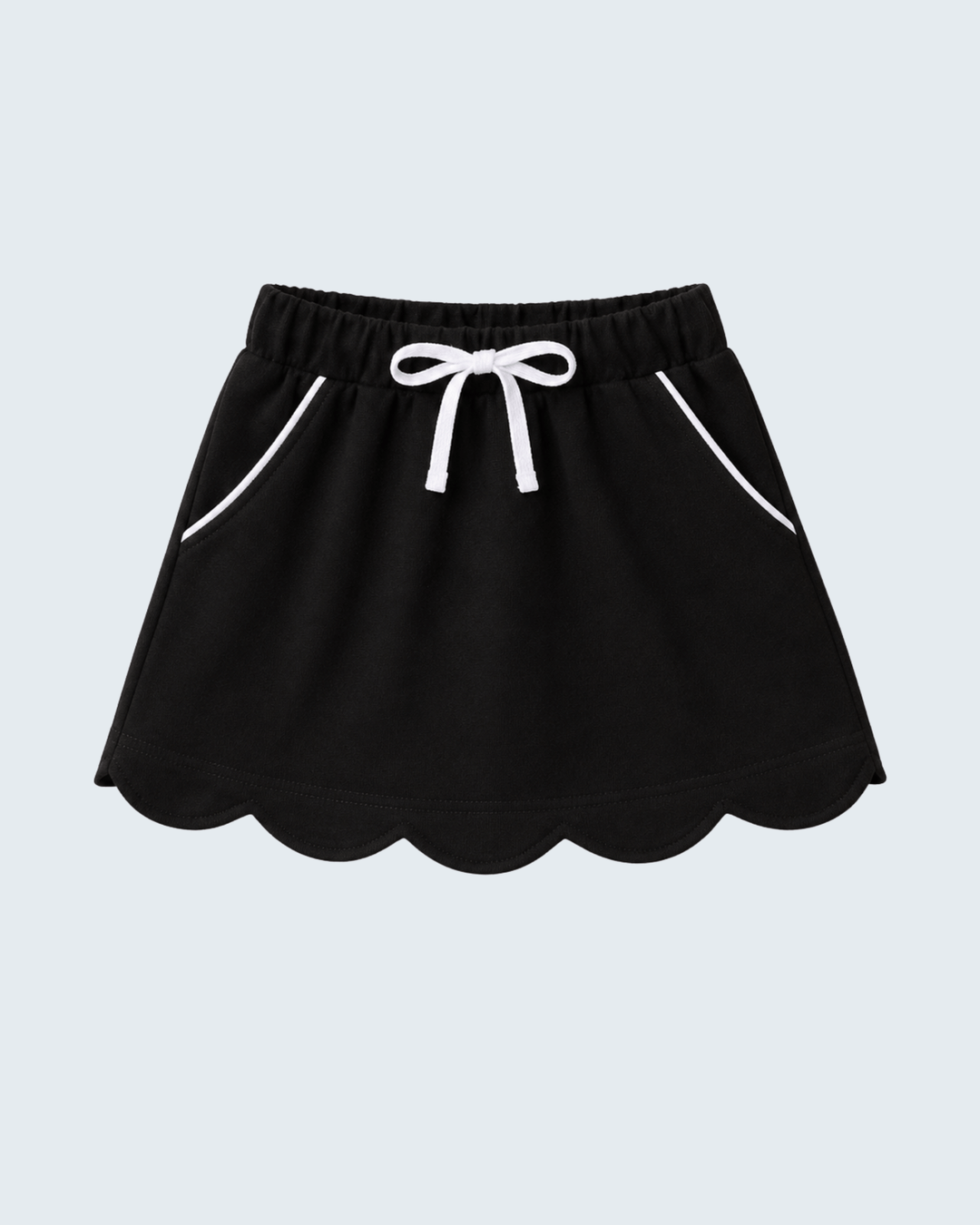 A black mini skirt with a scalloped hem, white drawstring bow at the elastic waist, and white piping details on the side pockets, shown against a light gray background.