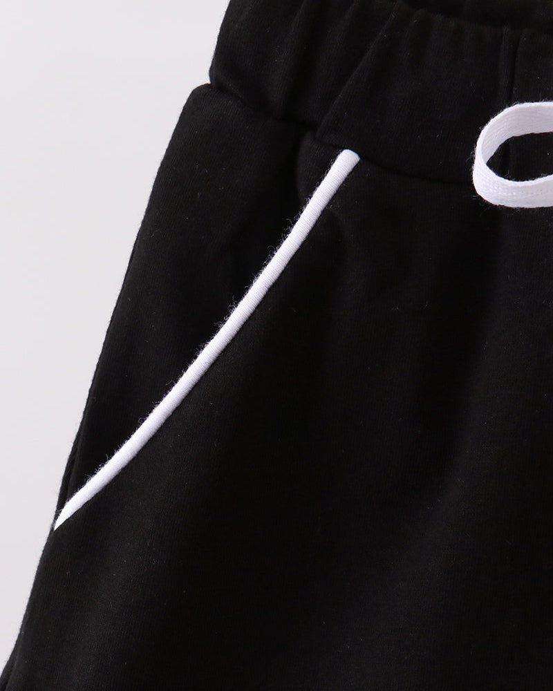 Black skort fabric close-up with white ribbon tie detail and elastic waistband
