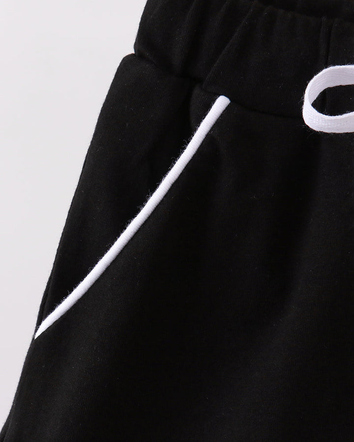 Black skort fabric close-up with white ribbon tie detail and elastic waistband