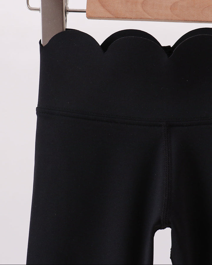 Black leggings on a hanger against a white background