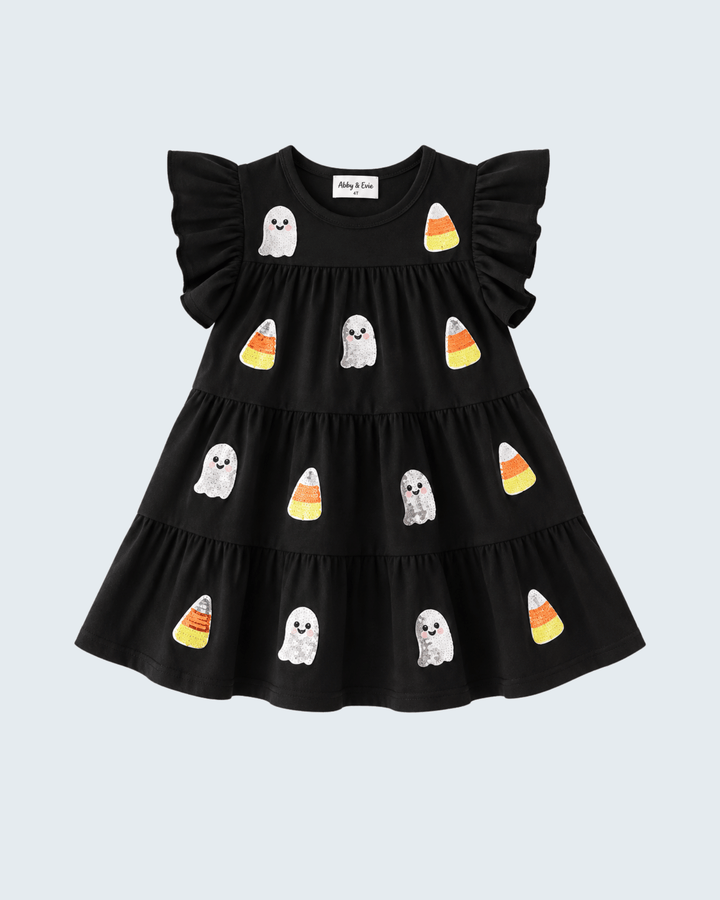 A black tiered baby dress with ruffled sleeves, decorated with cute ghost and candy corn illustrations, shown against a light gray background.