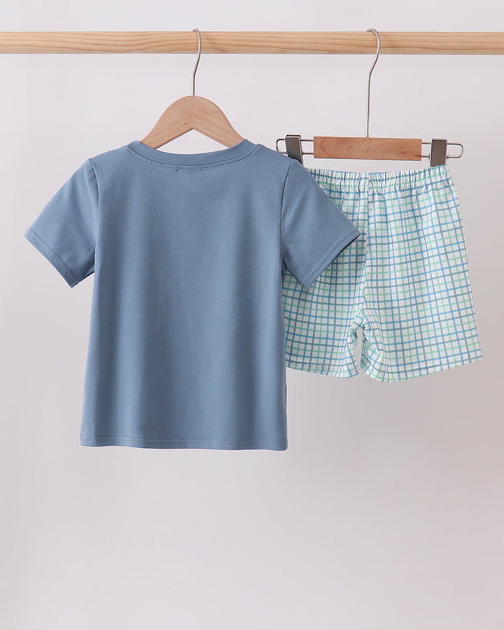 Boys blue short-sleeve tee with matching light plaid shorts set, view from back