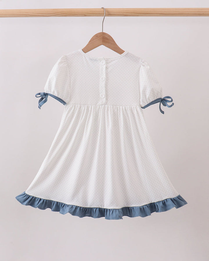 Girls white dotted dress with blue ruffle hem, bow sleeves, and gathered skirt