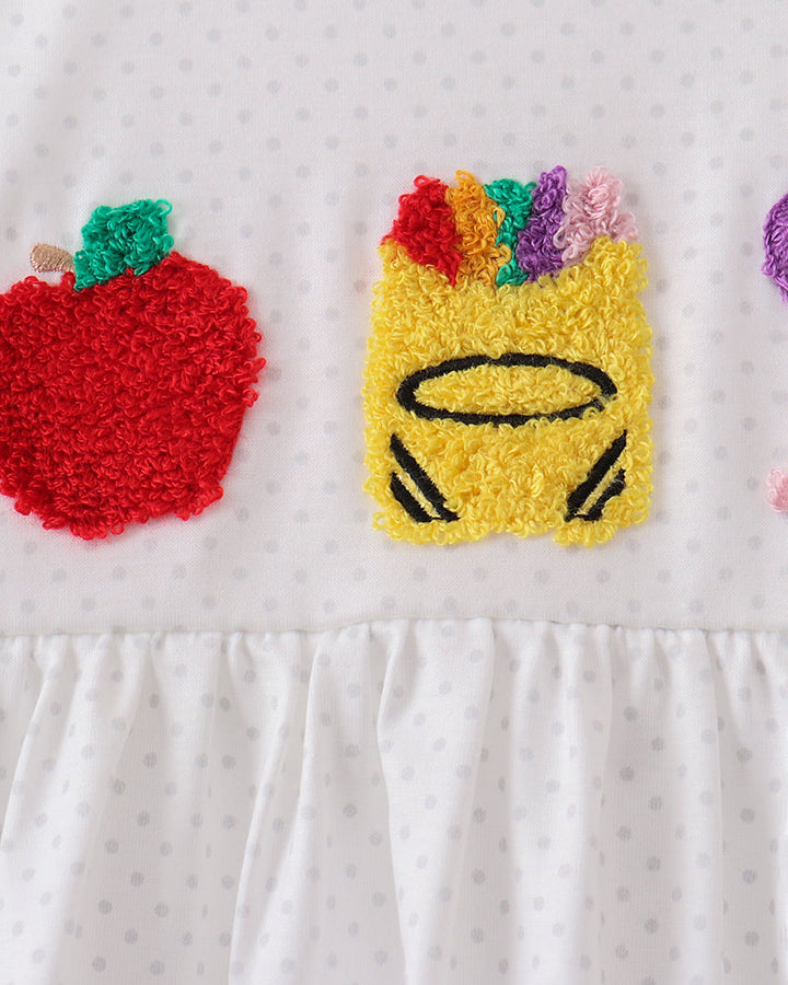 White ruffle top close-up with colorful crayon applique and small blue bow details