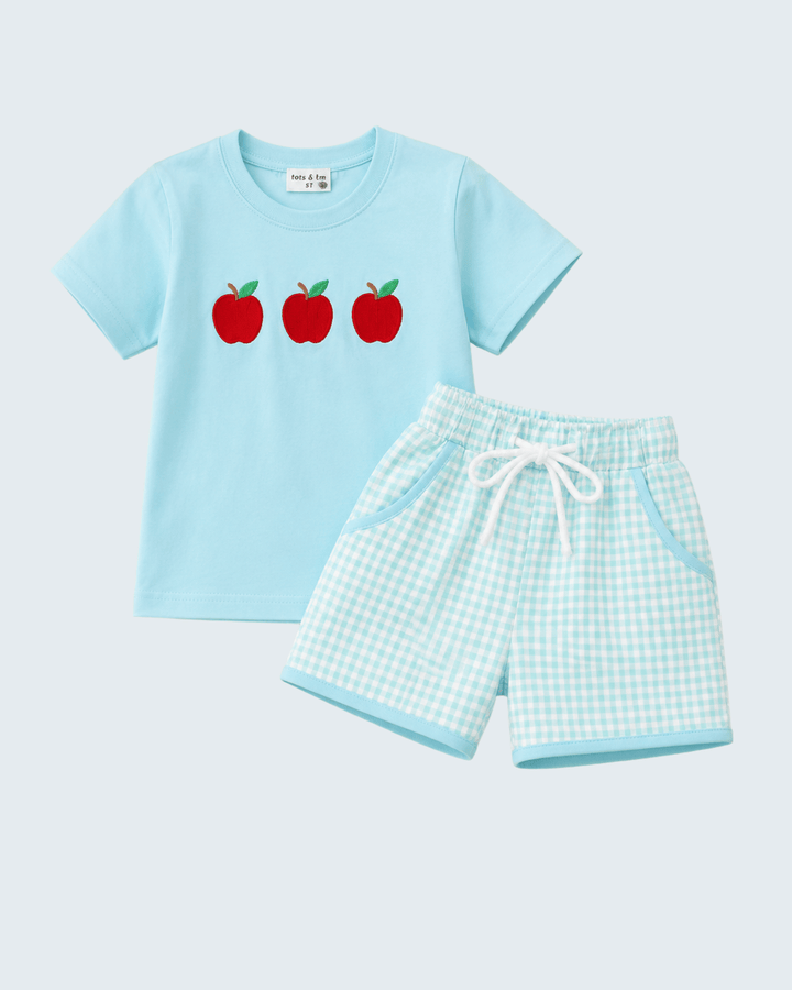 Light blue t-shirt with red apples and matching shorts on a light gray background