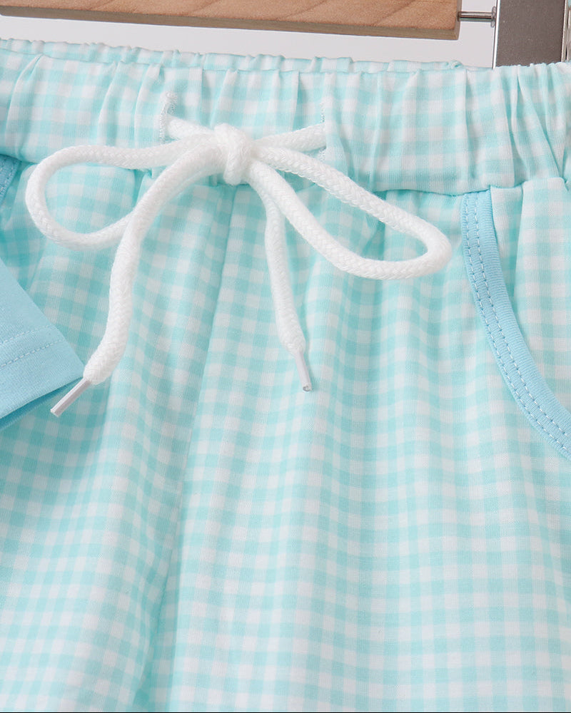 Light blue checkered shorts with white drawstring on a hanger.