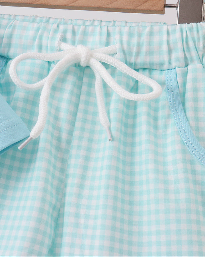 Light blue checkered shorts with white drawstring on a hanger.