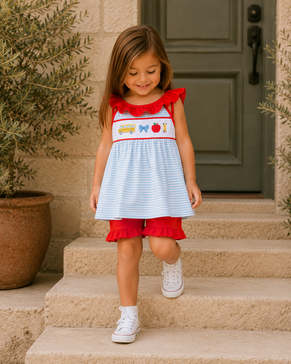Girls wearing striped dress and red shorts set with ruffle bows and embroidery