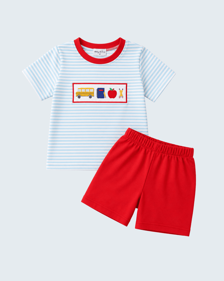 Light blue striped T-shirt with red trim and graphic chest panel, paired with red shorts.