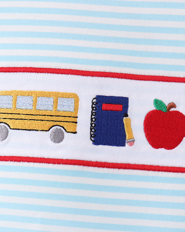 Light blue striped fabric with red trim and embroidered bus, pencil, and apple details