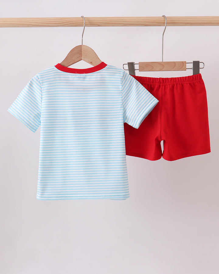 Kids striped light blue T-shirt and red shorts set, hanging on wooden hangers.