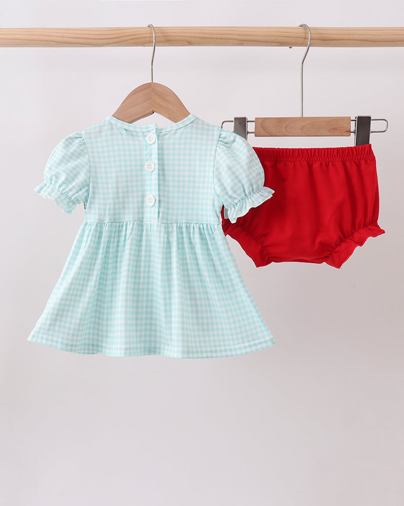 Light blue checkered dress with white ruffled sleeves and red bloomers on hangers against a light gray background.