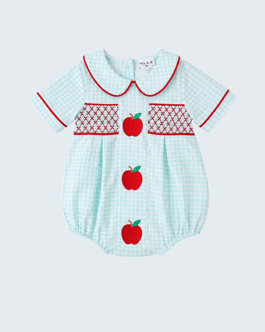 Light blue checkered baby romper with red apple designs on a white background