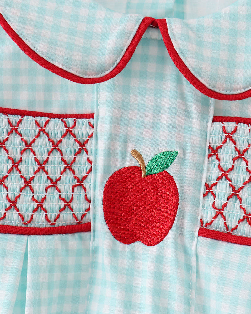 Baby romper with red apple design on a checkered background