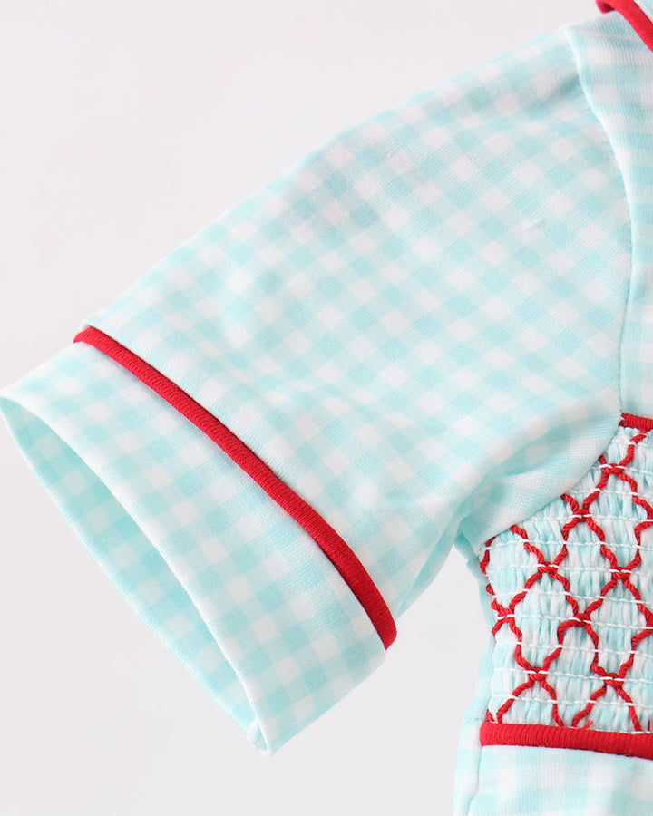Light blue baby outfit with red accents on a white background