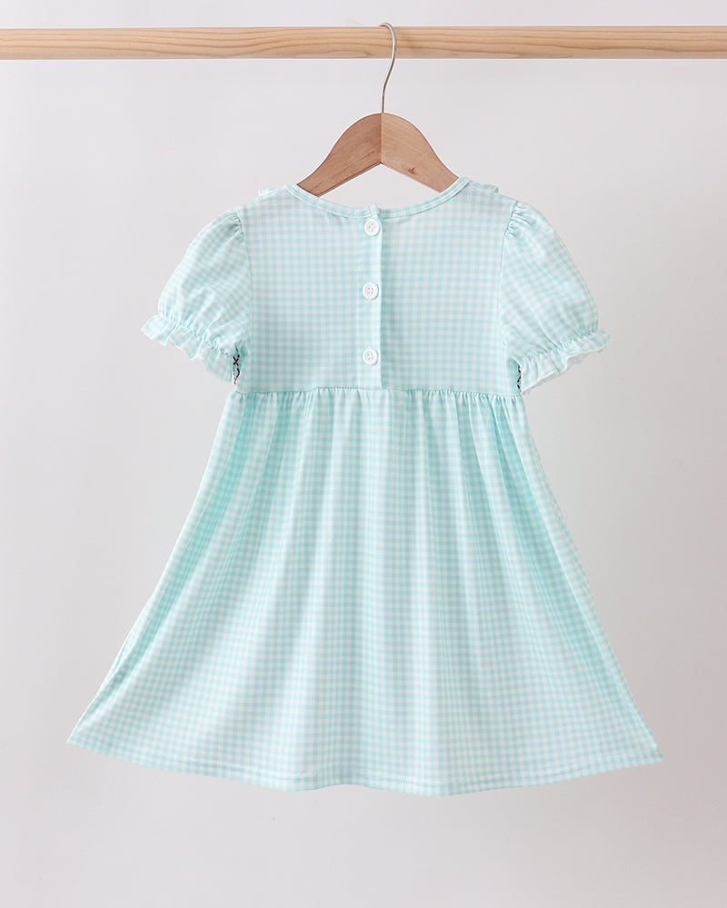 Light blue checkered dress on a hanger against a plain background