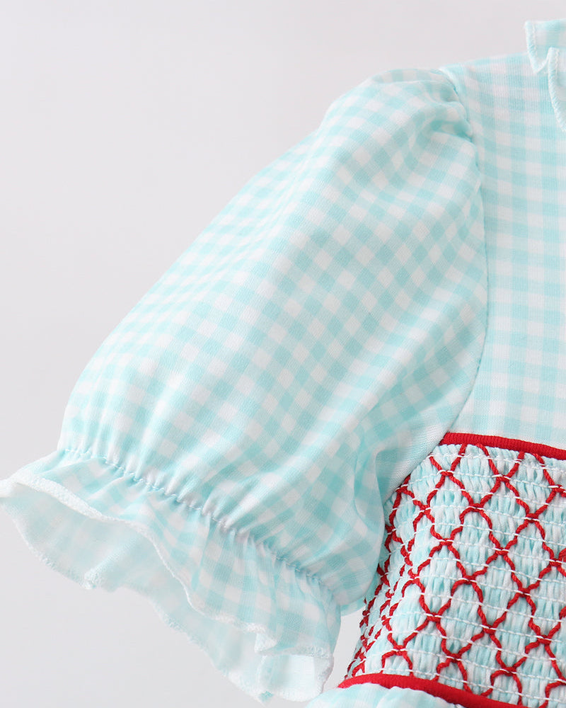 Light blue checkered dress with red embroidery on a light gray background