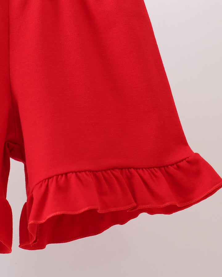 Red shorts with ruffled hem on a light gray background