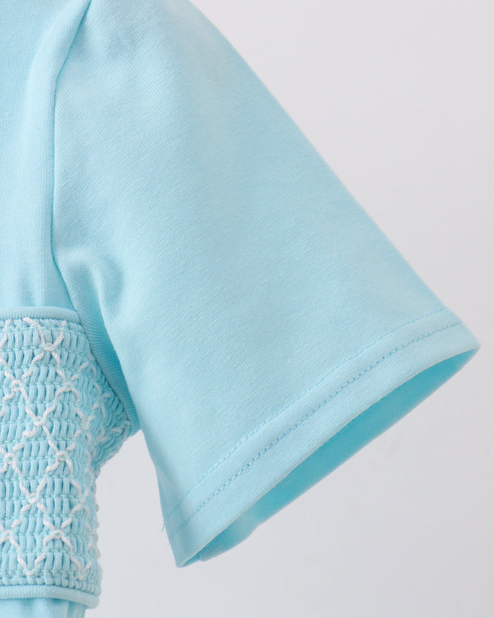 Light blue smocked sleeve cuff with gathered trim