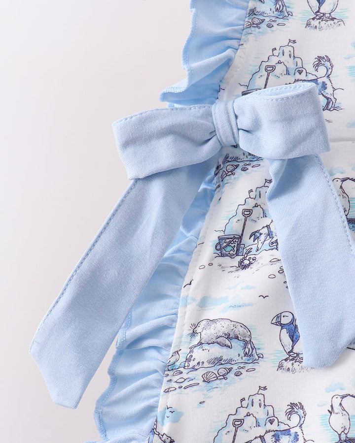 Baby outfit with blue ruffled top and patterned white pants on a hanger.