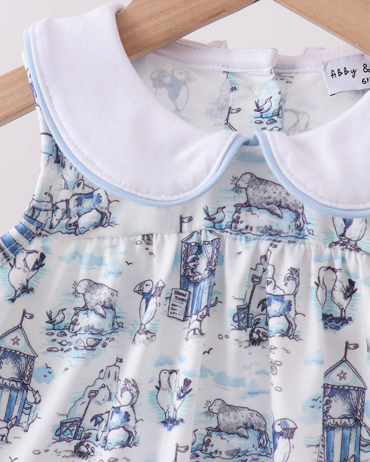 Baby dress with blue and white animal print on a wooden hanger