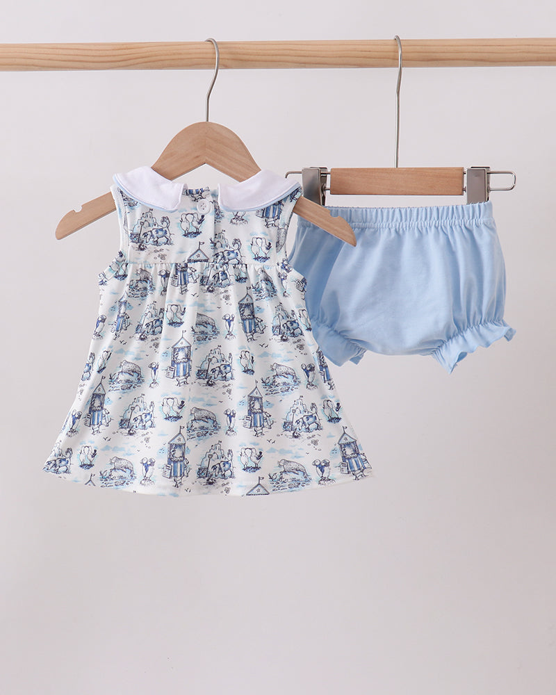 Baby dress with blue and white pattern and matching bloomers on hangers against a light background